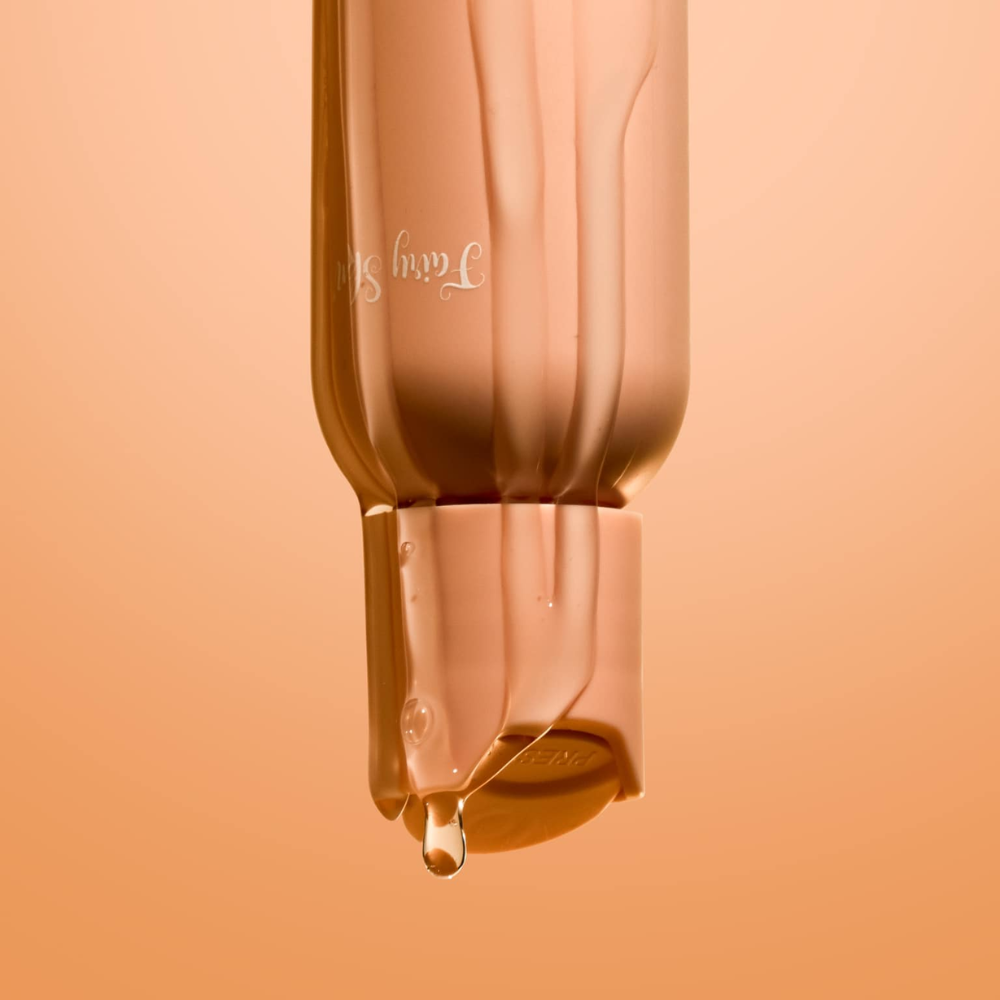 Close-up of a cosmetic bottle with a droplet on an orange background Fairy Skin  Derma Facial Kit - Pimple Fighting and Skin Renewing