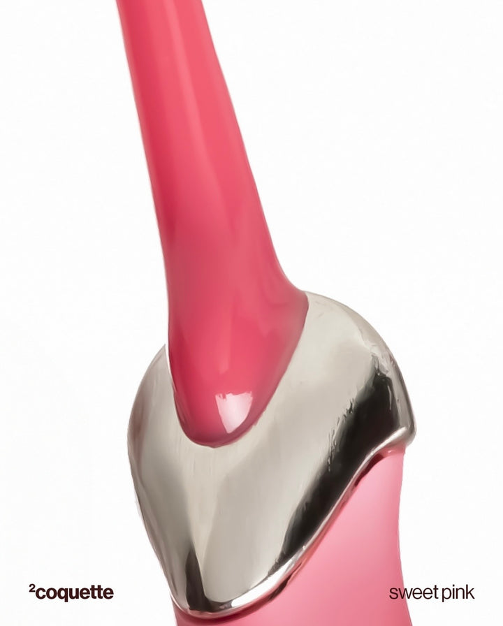 Close-up of a pink and silver product with 'coquette' branding on a white background.