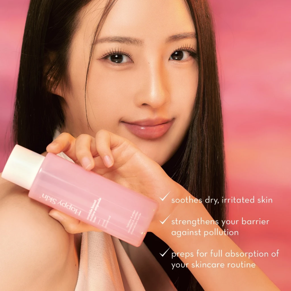 Woman holding a pink skincare bottle with text on a pink background