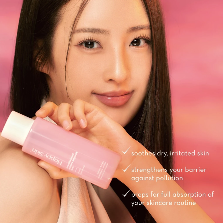 Woman holding a pink skincare bottle with text on a pink background