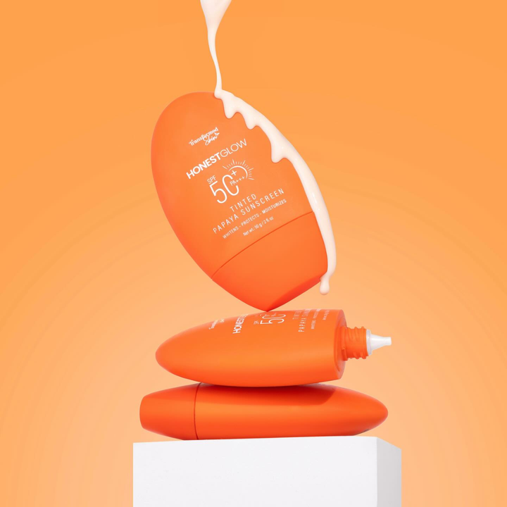 Orange sunscreen bottles with a white cap on an orange background