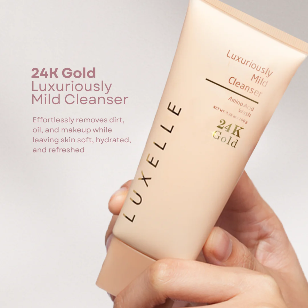 Luxelle 24K Gold Luxuriously Mild Cleanser tube held by a hand against a light gray background