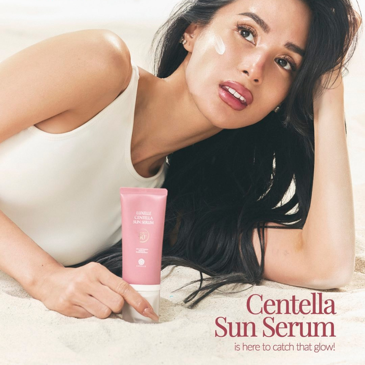 Luxelle Centella Sun Serum SPF PA 50+++ Heart Evangelista Woman holding a pink Centella Sun Serum bottle with a white background
