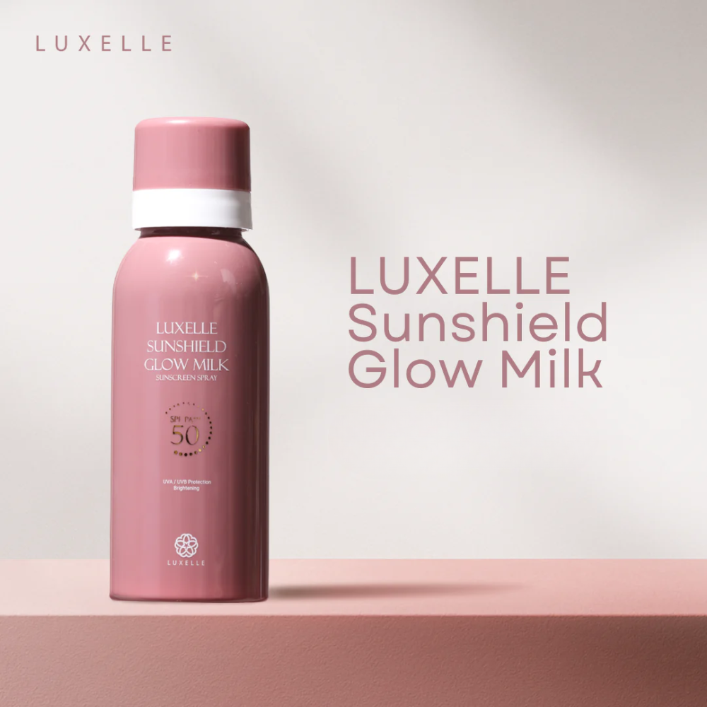 Pink bottle of Luxelle Sunshield Glow Milk on a light pink background Luxelle Sunshield Glow Milk Sunscreen Spray
