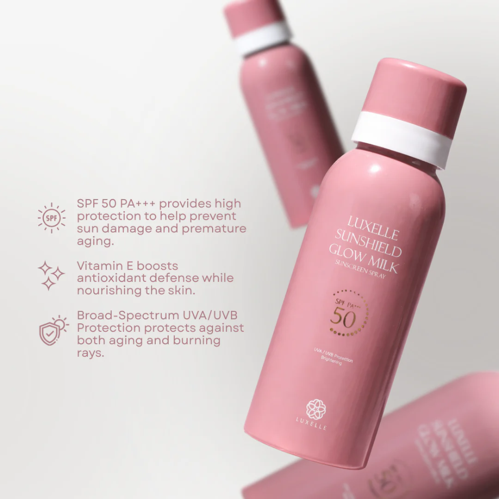Pink sunscreen bottle with text on a light gray background Luxelle Sunshield Glow Milk Sunscreen Spray