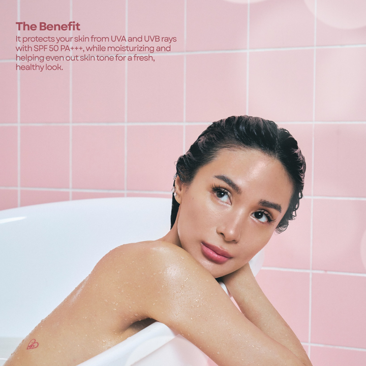 Woman in a bathtub with pink tiled walls and product description text. Luxelle Sunshield Glow Milk Sunscreen Spray