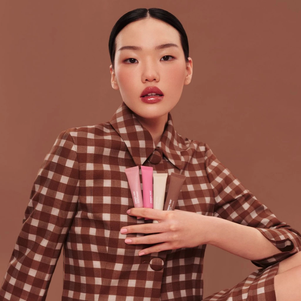 Sunnies Face Lip Glaze - a peptide lip treatment Model holding products