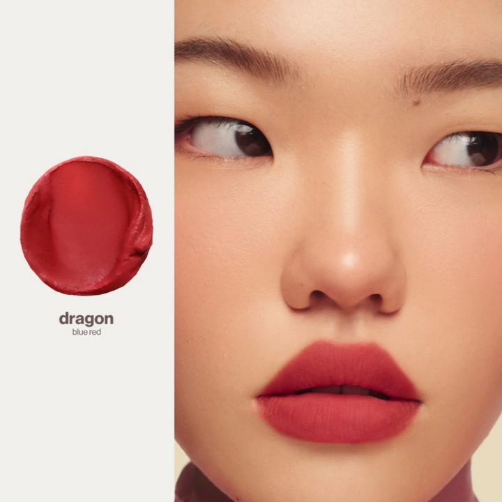 Close-up of a person wearing red lipstick with a color swatch labeled 'dragon' on a beige background. Sunnies Face Lip Dip - Dragon