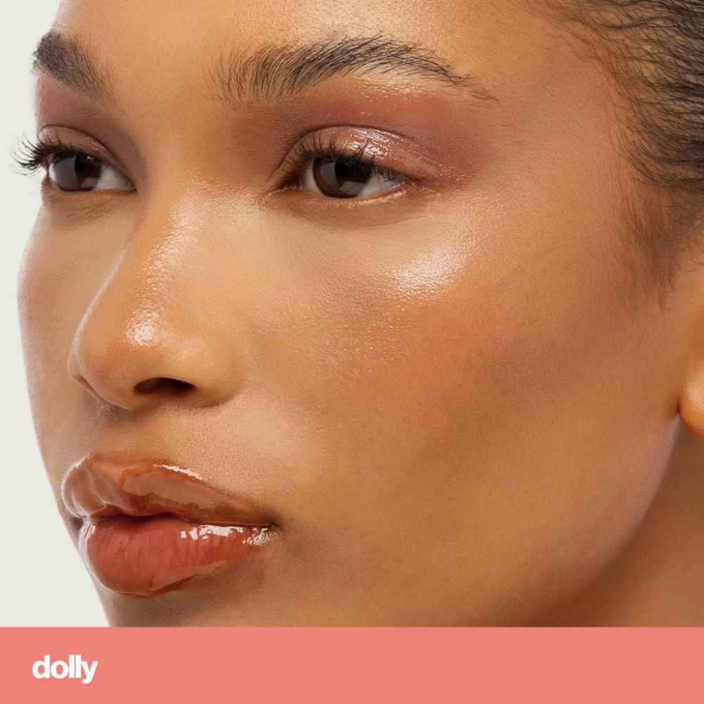 Close-up of a woman's face with a neutral background, featuring the brand 'dolly'. Sunnies Face Lip Glaze - a peptide lip treatment