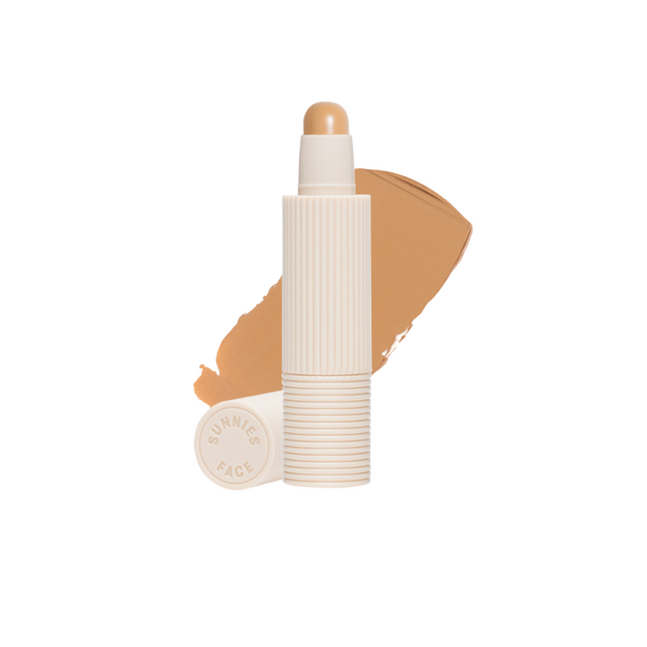 Concealer stick with applicator on a white background