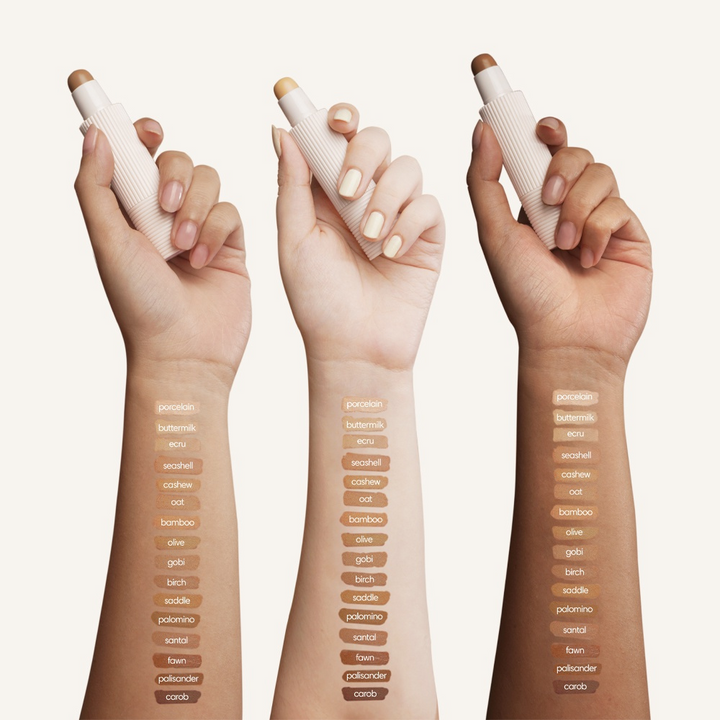 Three hands holding makeup products with color swatches on arms