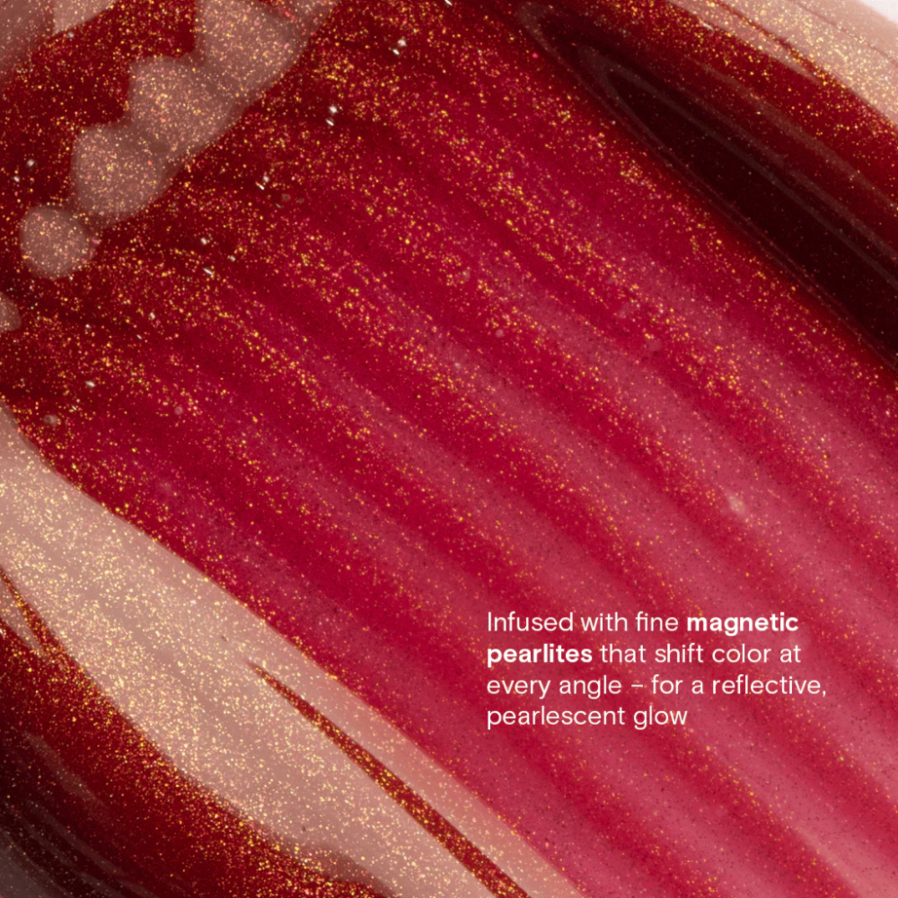 Close-up of a red and gold glittery substance with text describing its properties. Blk Cosmetics Hypergloss - Pearlescent Shine + Juicy Hydration