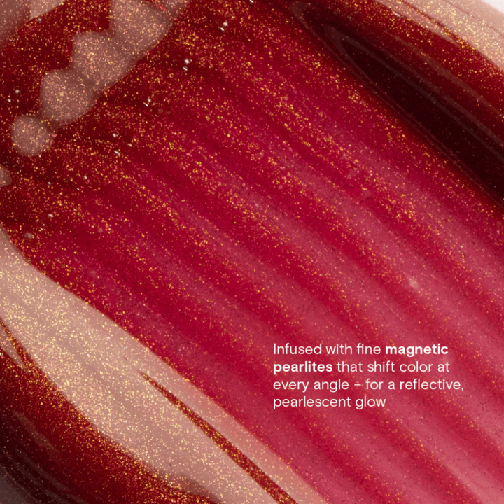 Close-up of a red and gold glittery substance with text describing its properties. Blk Cosmetics Hypergloss - Pearlescent Shine + Juicy Hydration