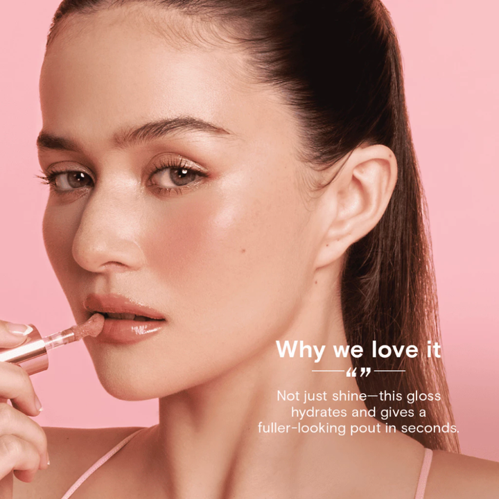 Woman applying lip gloss with a pink background and text about the product's benefits. Blk Cosmetics Hypergloss - Pearlescent Shine + Juicy Hydration